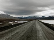 Estrada que se estende através da paisagem de montanha de inverno — Fotografia de Stock