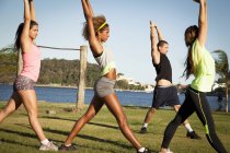 Three young women stretch training in  park — Stock Photo
