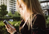 Junge Frau mit Smartphone im Freien — Stockfoto