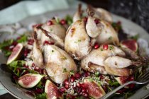 Close up of serving plate of roasted wildfowl and figs — Stock Photo