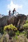Junges Paar auf Mountainbikes blickt auf Aussicht — Stockfoto