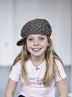 Retrato de sorrindo bonito menina vestindo um tweed cap — Fotografia de Stock