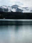 Fog over mountains and still lake — Stock Photo