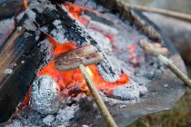 Salsicce arrosto sul fuoco barbecue — Foto stock