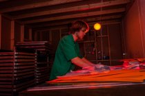 Man working in darkroom in screen printing workshop — Stock Photo