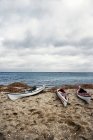 Kayaks on sandy beach with cloudy sky — Stock Photo