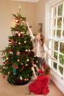 Fille avec soeur décoration arbre de Noël — Photo de stock