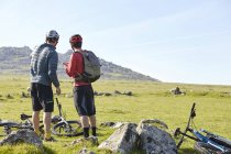 Cyclists on hillside chatting — Stock Photo