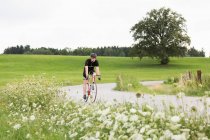 Mature cycliste masculin sur la route de campagne — Photo de stock