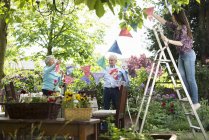 Grandparents and granddaughter hanging up bunting — Stock Photo