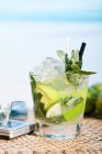 Glas Mojito-Cocktail und Handy auf dem Tisch — Stockfoto