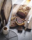 Beef wellington on cutting board with knife — Stock Photo