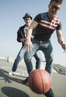 Молодые люди играют в баскетбол в скейтпарке — стоковое фото