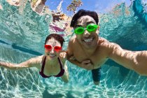 Young couple swimming underwater in pool — Stock Photo