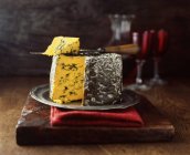 Blacksticks fromage bleu rond sur planche à découper en bois avec couteau à fromage — Photo de stock