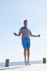 Man on pier using skipping rope — Stock Photo