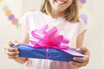 Cropped view of girl holding gift smiling — Stock Photo