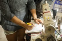 Plan recadré de couturières prenant des notes dans un atelier de couture — Photo de stock