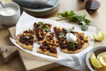Middle eastern lamb and chickpea pizza with herb garnish and lemon slices — Stock Photo