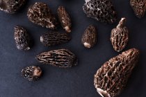 Top view of dried morel mushrooms on dark blue table — Stock Photo