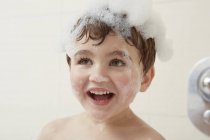 Junge in Badewanne mit Blasen am Kopf — Stockfoto