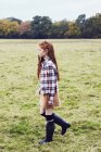 Jeune fille, marche à travers le champ — Photo de stock