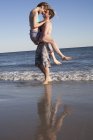 Pareja divirtiéndose en la playa, Breezy Point, Queens, Nueva York, Estados Unidos - foto de stock
