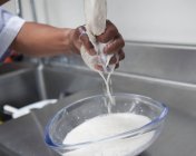Vista ravvicinata della donna che strizza il latte di mandorla dalla garza — Foto stock