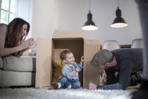 Eltern spielen mit Baby und Karton — Stockfoto