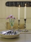 Тарелки, столовые приборы и зажженные свечи на обеденном столе — стоковое фото