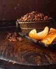 Cesta de frutas secas y cáscara de naranja sobre mesa de madera - foto de stock