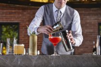 Schnappschuss von Barkeeper bei der Zubereitung von Cocktail — Stockfoto