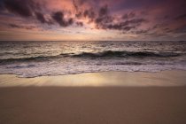 Cielo nuvoloso all'alba sull'oceano e sulla costa — Foto stock
