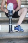 Sprinter preparing, putting on prosthetic leg — Stock Photo