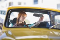 Red haired Woman driving a car — Stock Photo