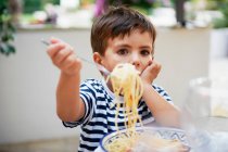 Giovane ragazzo mangiare spaghetti — Foto stock
