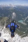 Man base jumping from mountain edge, Alleghe, Dolomites, Italy — Stock Photo