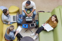 Overhead-Ansicht von vier männlichen und weiblichen Studenten Brainstorming in Hochschulstudienraum — Stockfoto