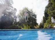 Niño saltando en la piscina - foto de stock