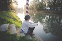 Молода жінка, сидячи на кроки до річки, Доло, Венеція, Італія — стокове фото