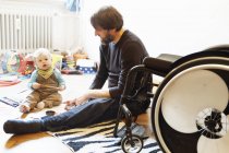 Padre disabile con figlio che gioca sul pavimento — Foto stock