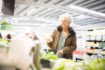 Donna matura al supermercato, guardando prodotti freschi — Foto stock