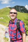 Reifer männlicher Wanderer mit Mineralwasser, Tirol, Österreich — Stockfoto