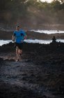 Мужчина бежит по скалистому берегу — стоковое фото
