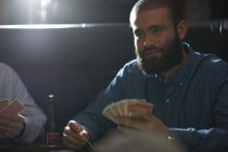 Amigos masculinos jogando jogo de cartas no tradicional pub do Reino Unido — Fotografia de Stock