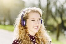 Retrato de adolescente escuchando auriculares - foto de stock
