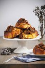 Sticky buns on cakestand and portion on plate — Stock Photo