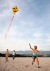 Діти літають повітряний змій на пляжі — стокове фото