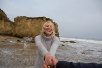 Зріла пара тримає руки на пляжі — стокове фото