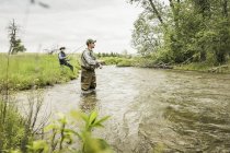 Hombre con vadeadores rodilla profunda en la pesca de agua en el río - foto de stock